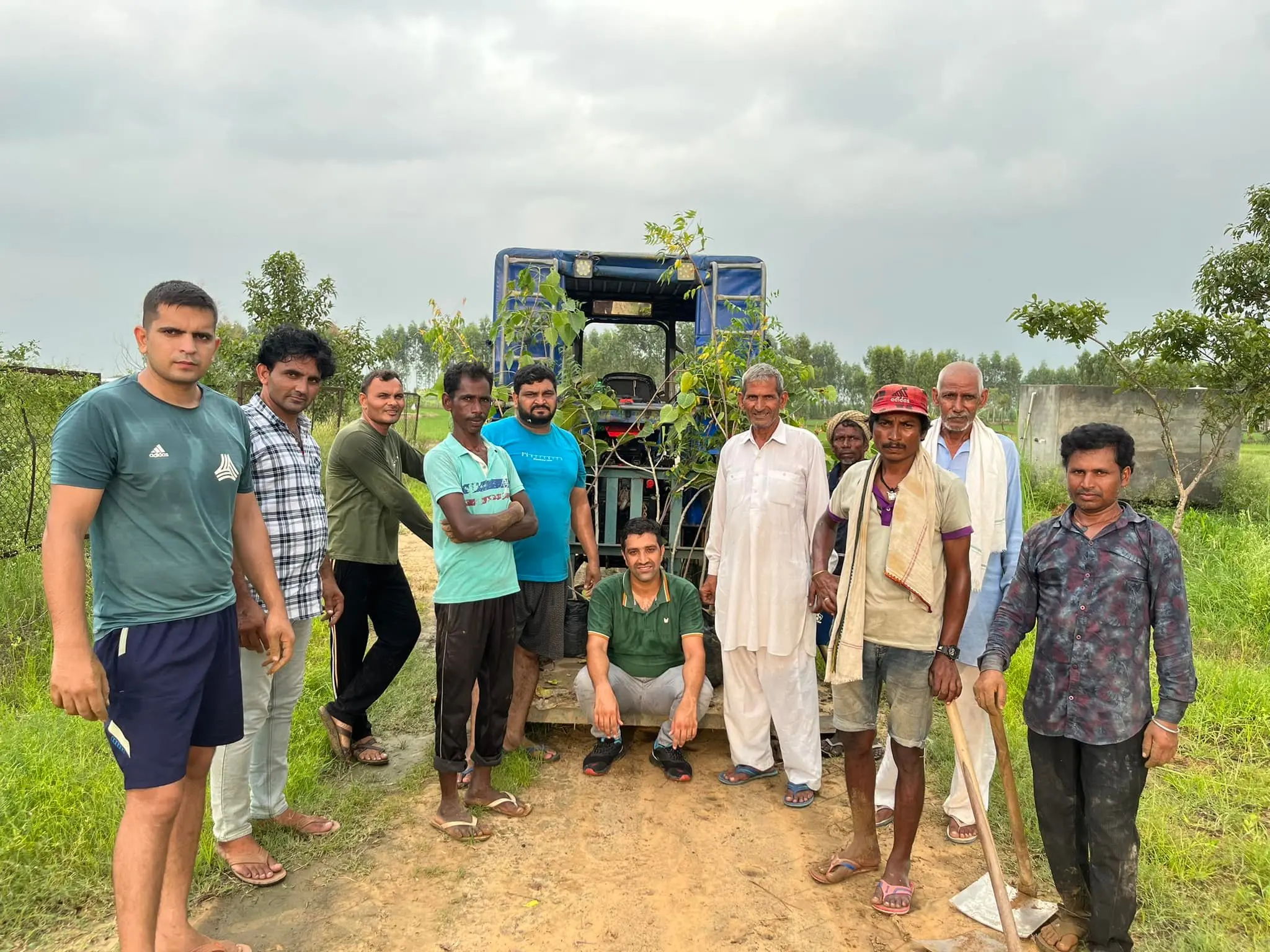 A group of people standing around in front of a tractor.