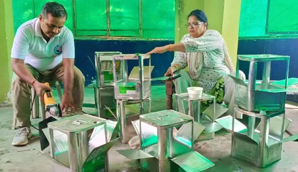 A woman sitting on the ground with several metal chairs.